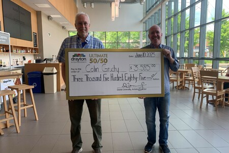 Colin Grunchy (left) is pictured holding a large presentation cheque for $3,585 alongside Drayton Entertainment Artistic Director David Connolly (right). The cheque, dated June 10, 2025, celebrates Colin as the winner of the Ultimate 50/50 draw. The<