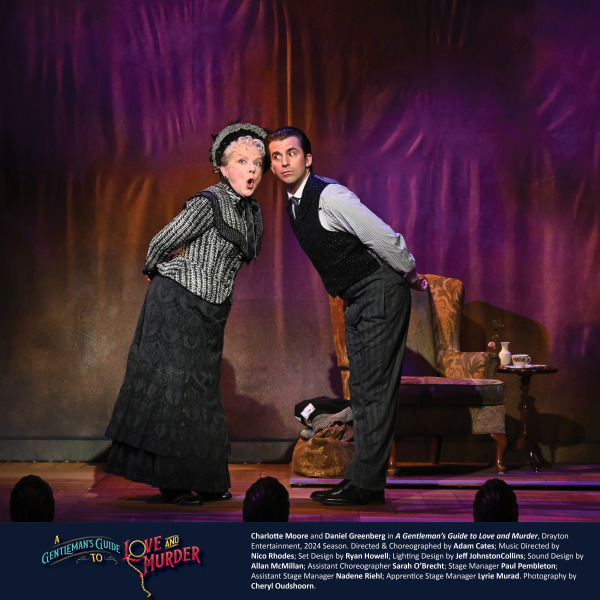 In this image from A Gentleman's Guide to Love and Murder, two actors are engaged in a comedic moment. The woman, dressed in a Victorian-era black and white ensemble with lace details and a bonnet, stands with a humorous expression, leaning forward. Beside her, a man in a vest and striped shirt mirrors her posture, both leaning toward the audience. The background is dimly lit with purple and warm tones, enhancing the playful and theatrical mood of the scene. A small side table with a teacup is visible in the background.