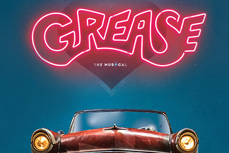 This promotional image for Grease features the title in bold, white letters against a sparkling, bokeh background. The backdrop transitions from warm golden tones at the top to cool blues at the bottom, creating a fun and lively atmosphere. The glowi