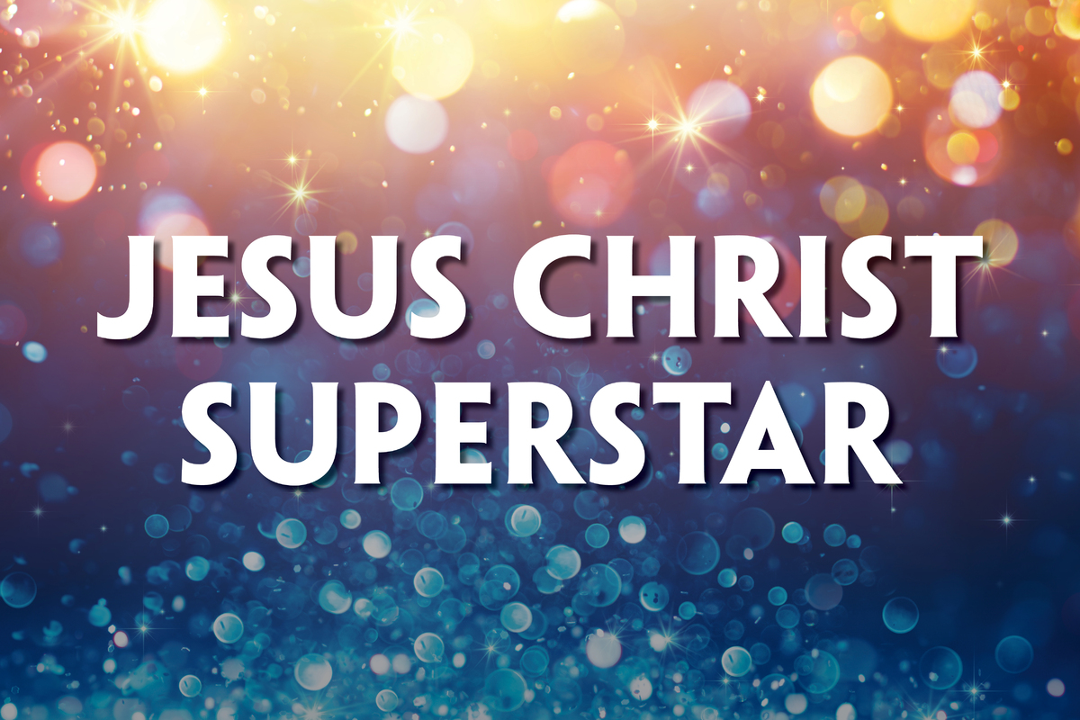 This promotional image for Jesus Christ Superstar features the title in bold, white letters against a sparkling, bokeh background. The backdrop transitions from warm golden hues at the top to cool blues at the bottom, with light sparkles adding a sen